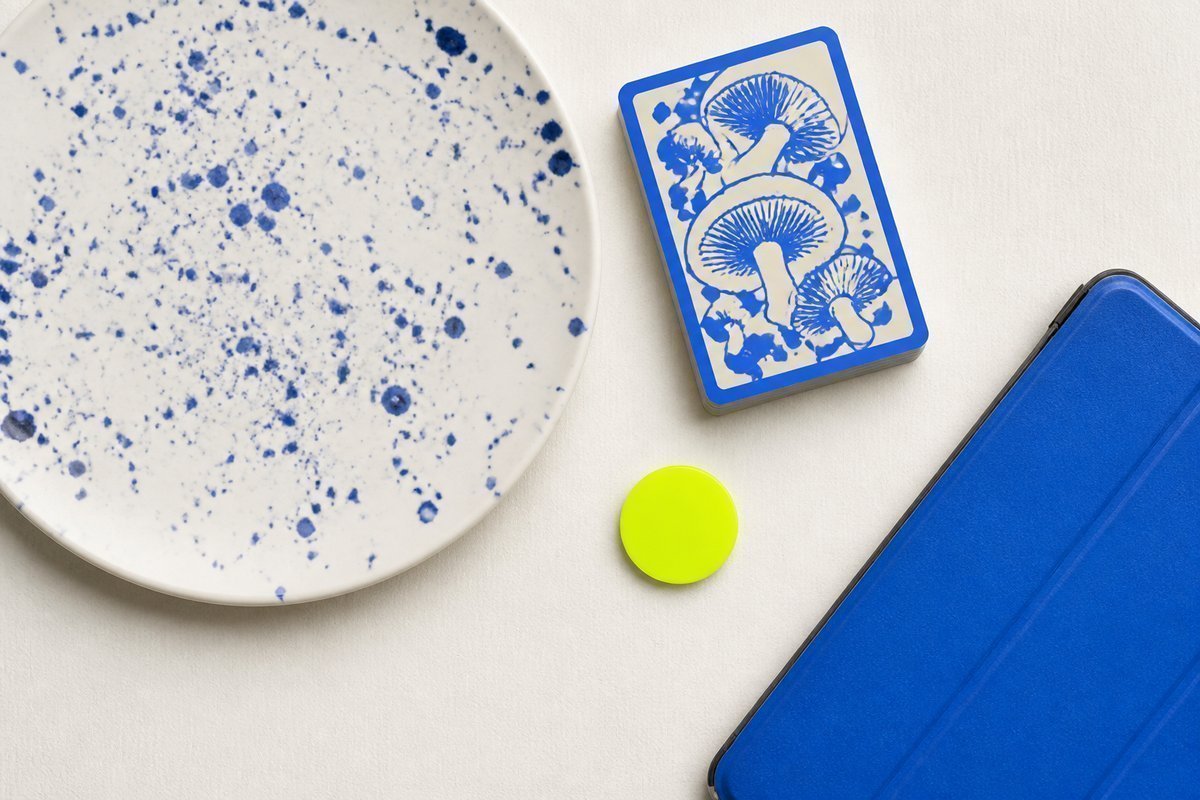Bone review card, cobalt edge, lime chip: heavy plate, delayed hand, blue tablet