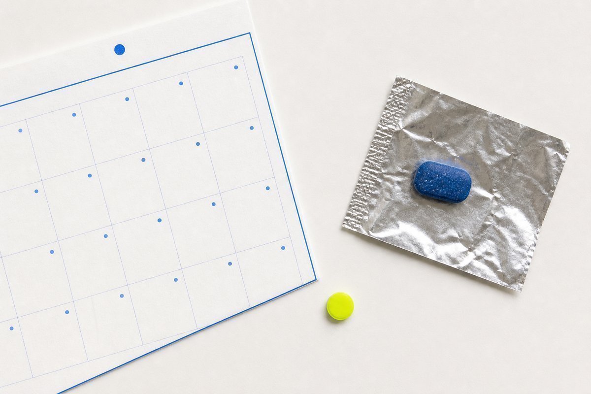 Bone review card, cobalt edge, lime chip: calendar leaf, blue tablet out of foil